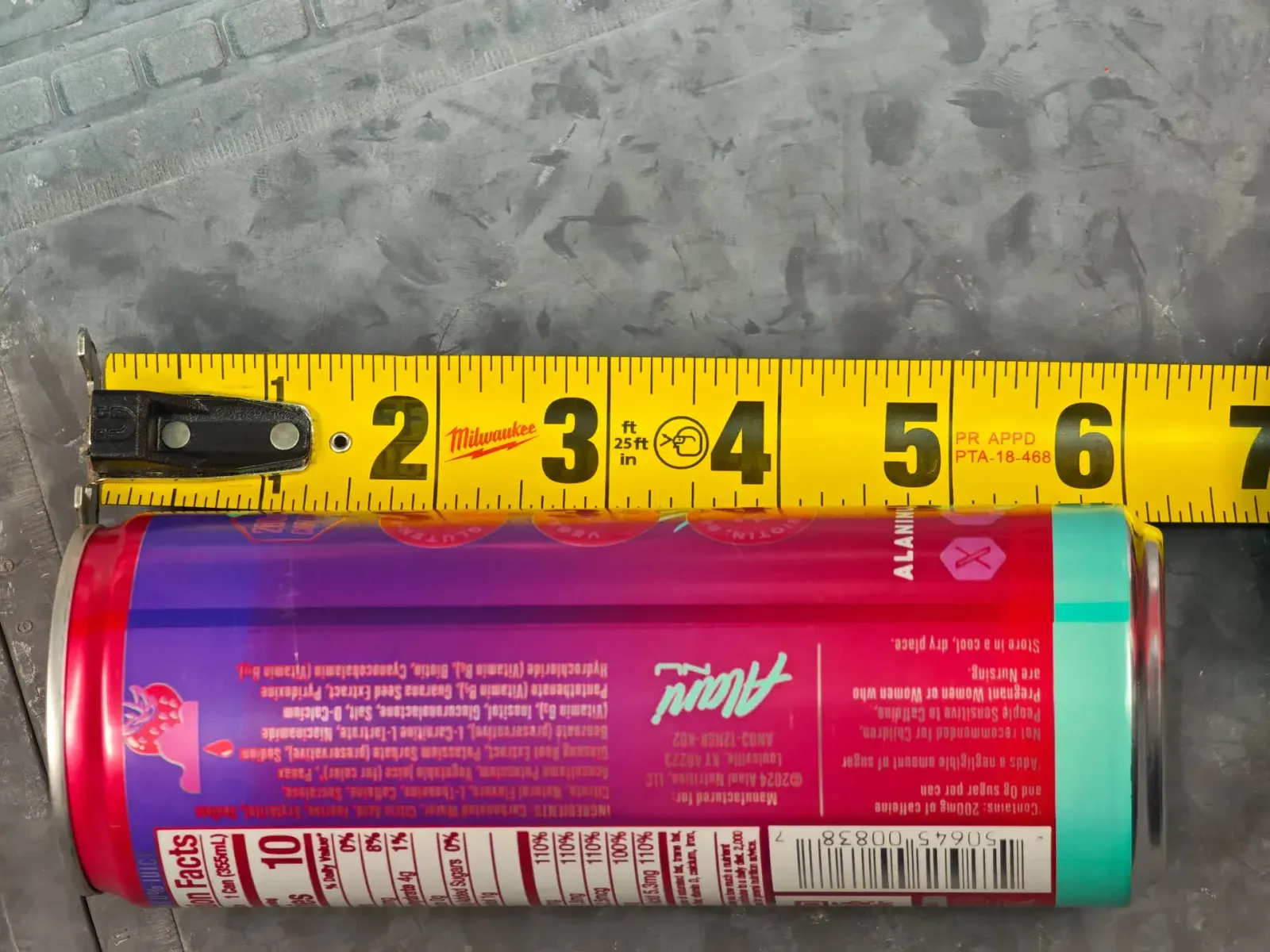 Measuring the can's length against a tape - about 156 mm